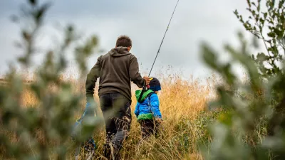 father and son walking through a field